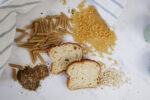Dry Pasta, Bread and oatmeal on a white background with a blue and white towel.