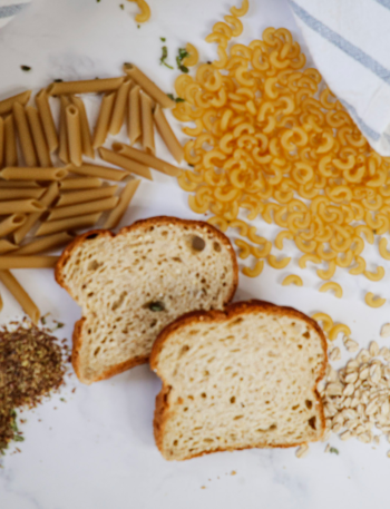 Dry Pasta, Bread and oatmeal on a white background with a blue and white towel.