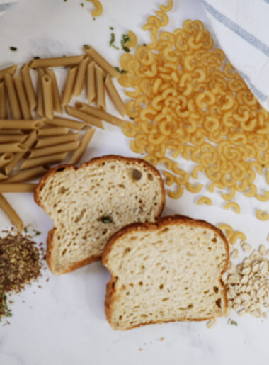 Dry Pasta, Bread and oatmeal on a white background with a blue and white towel.