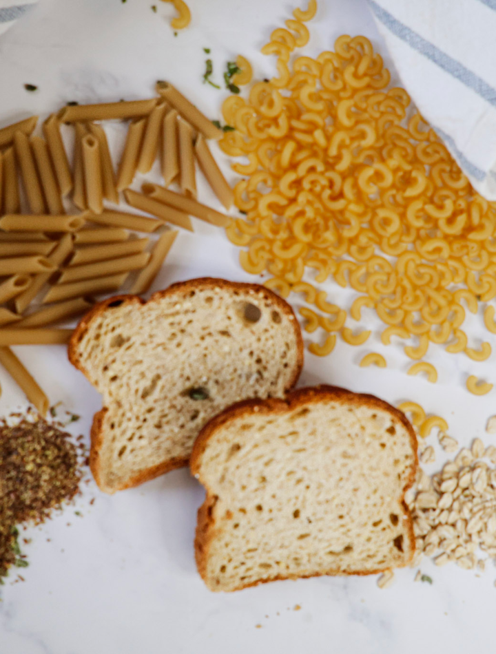 Dry Pasta, Bread and oatmeal on a white background with a blue and white towel.