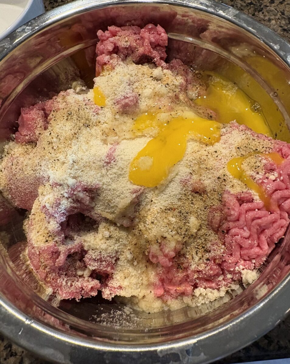 ground beef, eggs, almond flour and spices in a metal bowl