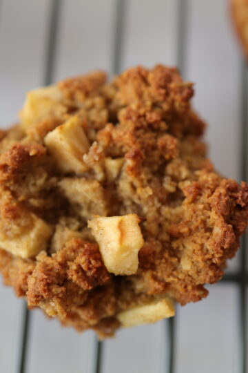 A gluten-free apple muffin on a wire drying rack